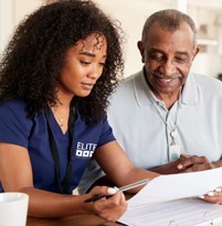 Caregiver helping elderly person with paperwork