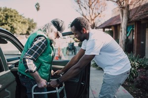 Caregiver holding walker for elderly